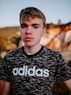 man wearing black and white adidas crew-neck t-shirt