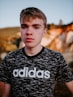 man wearing black and white adidas crew-neck t-shirt