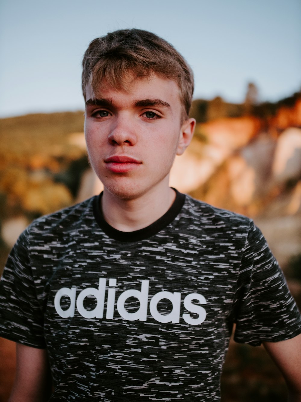 man wearing black and white adidas crew-neck t-shirt