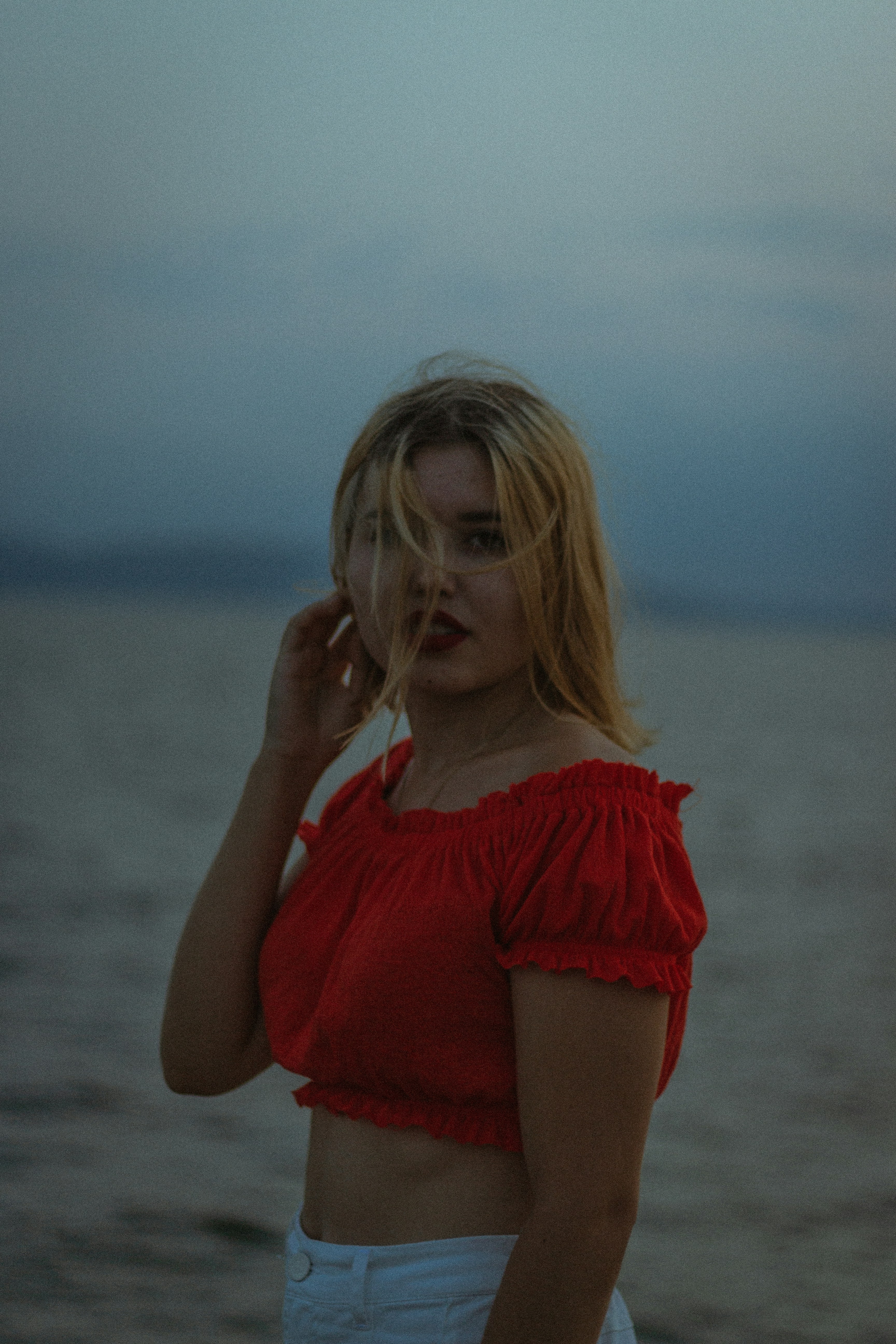 wanita mengenakan blus off-shoulder merah