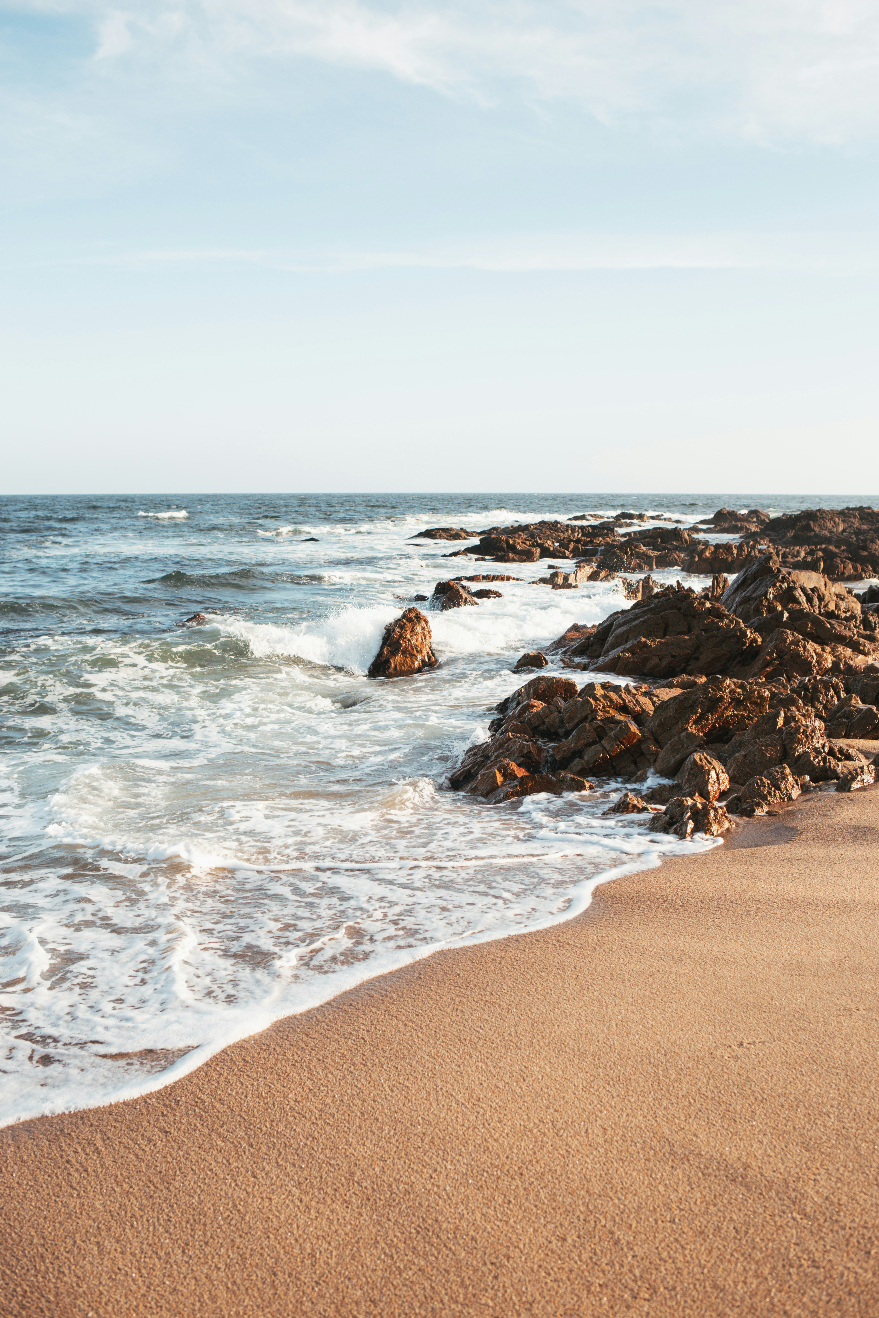 sea waves forming sea foam on rocky shore