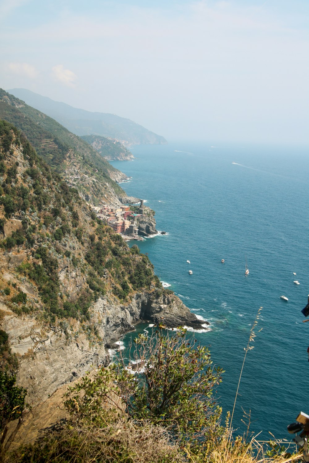 sea beside mountain range under clear blue sky