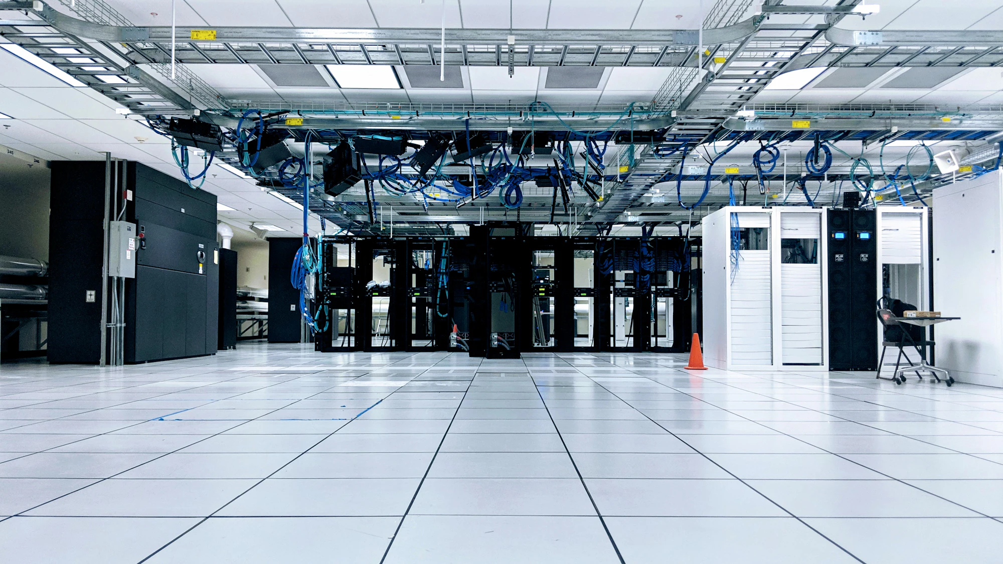 Rows of server cabinets with overhead cable trays in a data centre