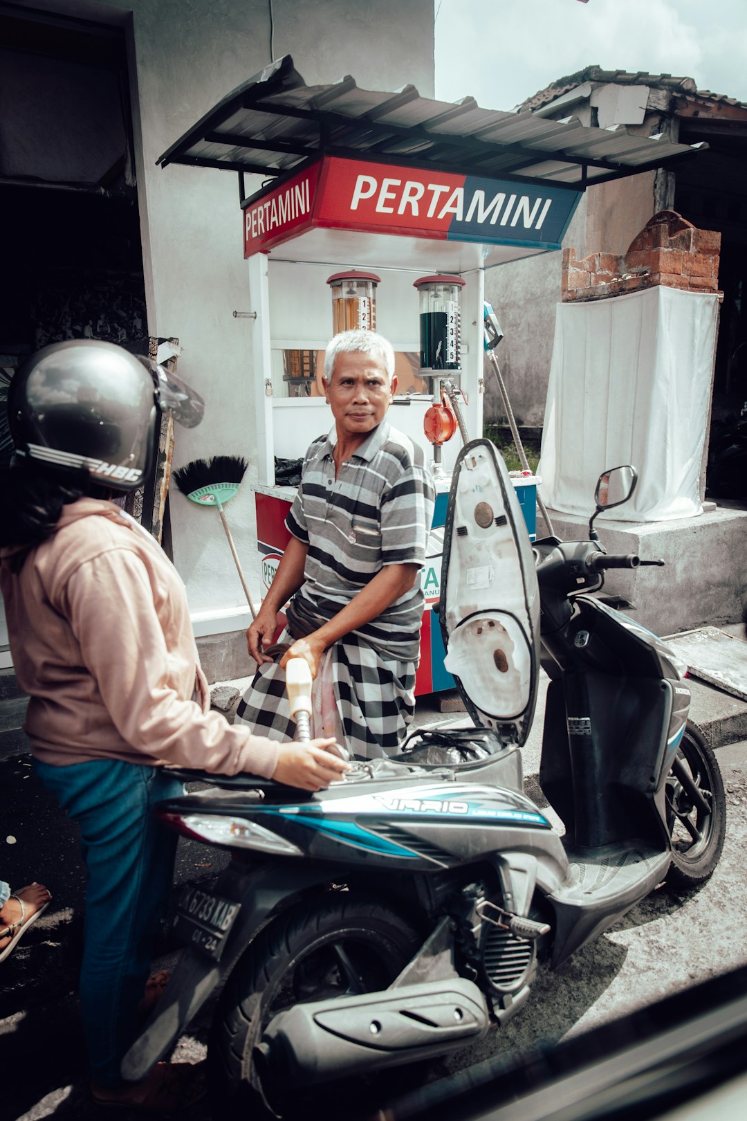 man standing beside motor scooter