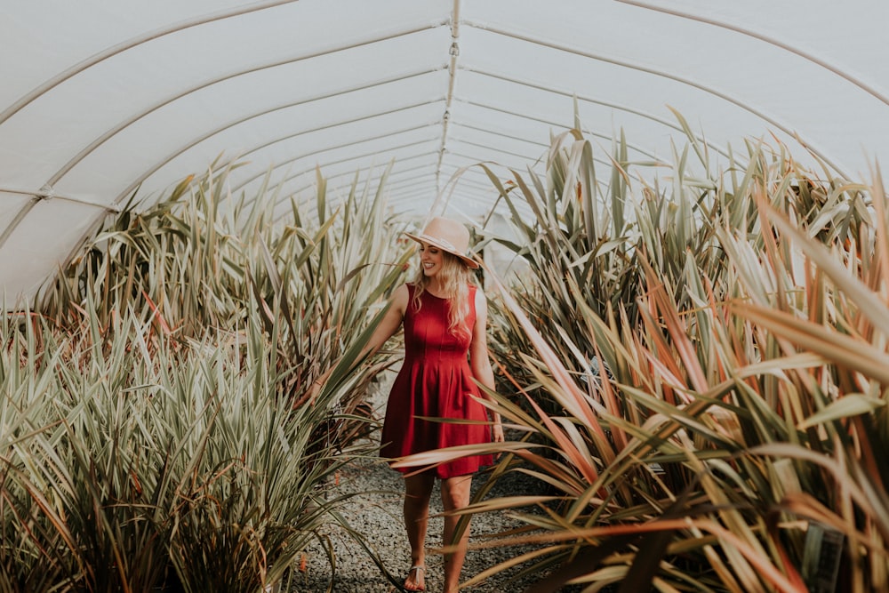 women's red mini dress standing between plants