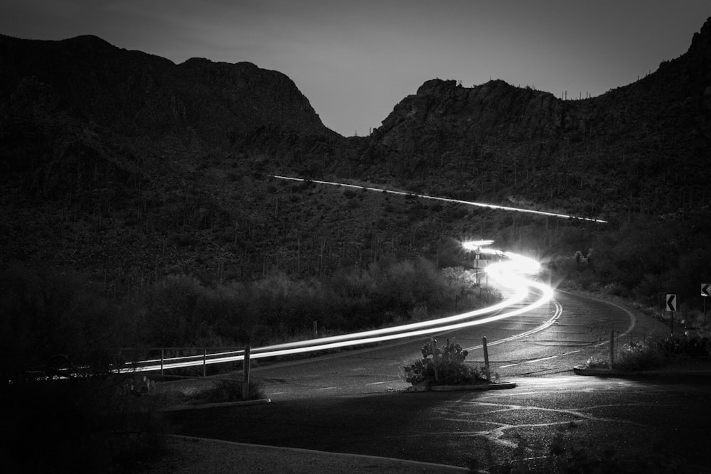 grayscale photography of road beside mountain