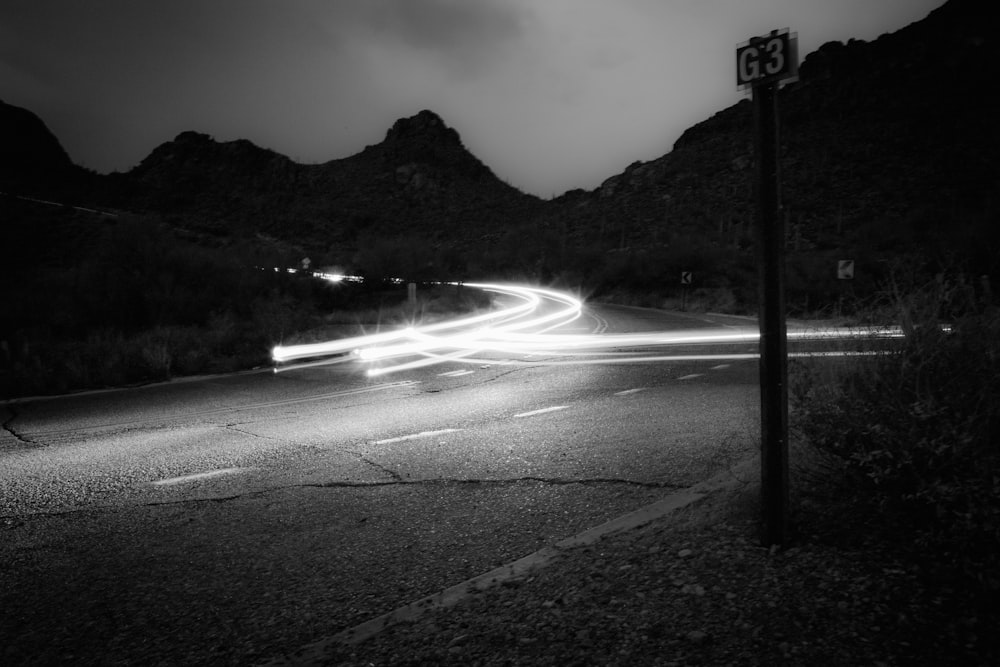 a black and white photo of a street at night