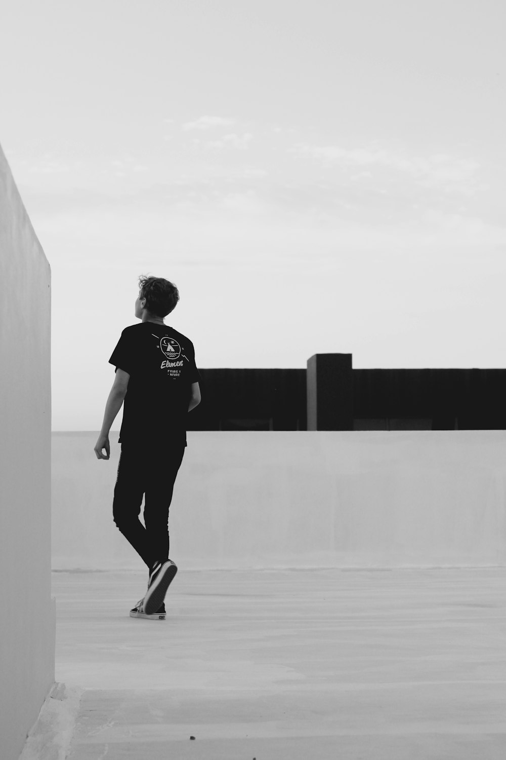 man walking beside wall