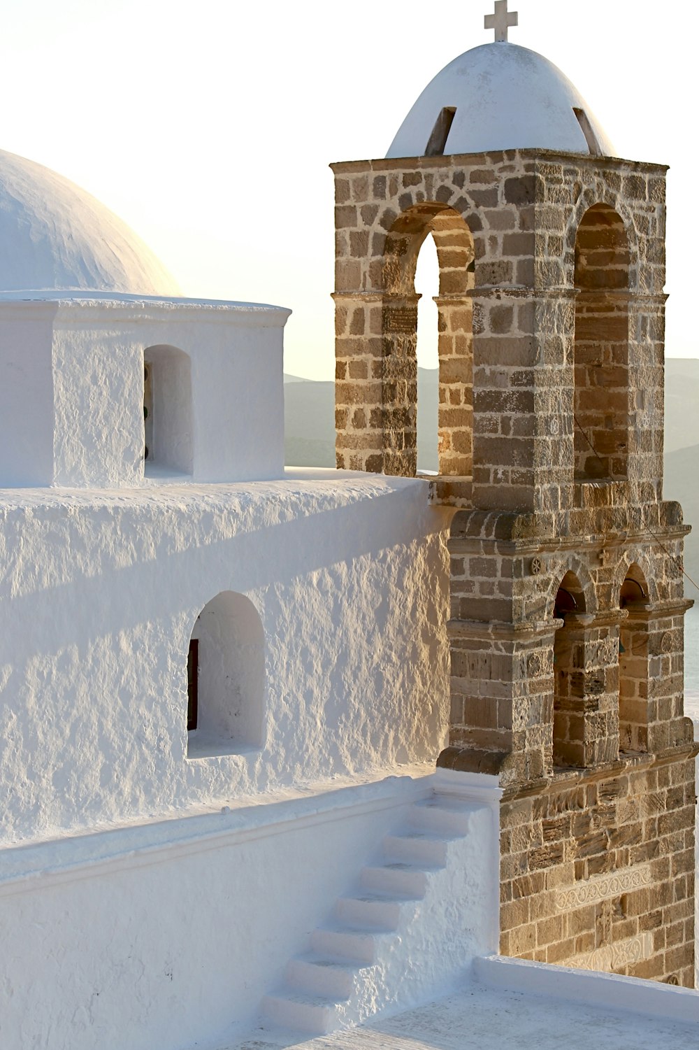 uma igreja branca com uma cruz em cima dela