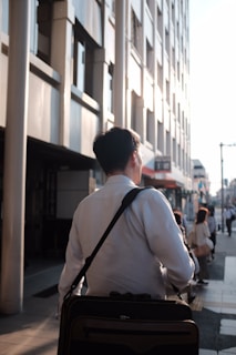 A happy customer carrying a Shine Republic leather bag while walking through a city street.