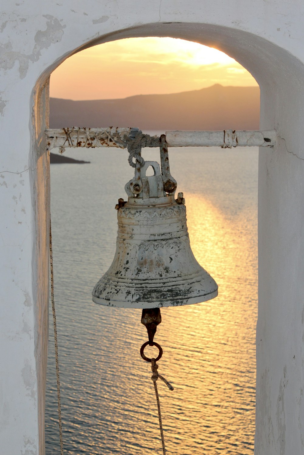 campana di metallo bianca e nera vicino allo specchio d'acqua