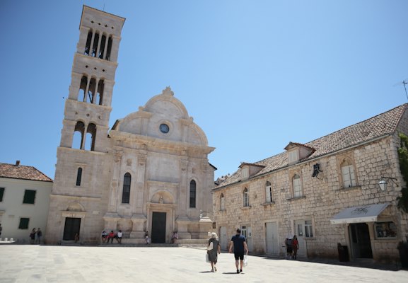 Two people walking outside building — Hvar, Croatia
