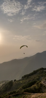 A scenic view of paragliders soaring over the lush mountains of Apía, Colombia at sunset.