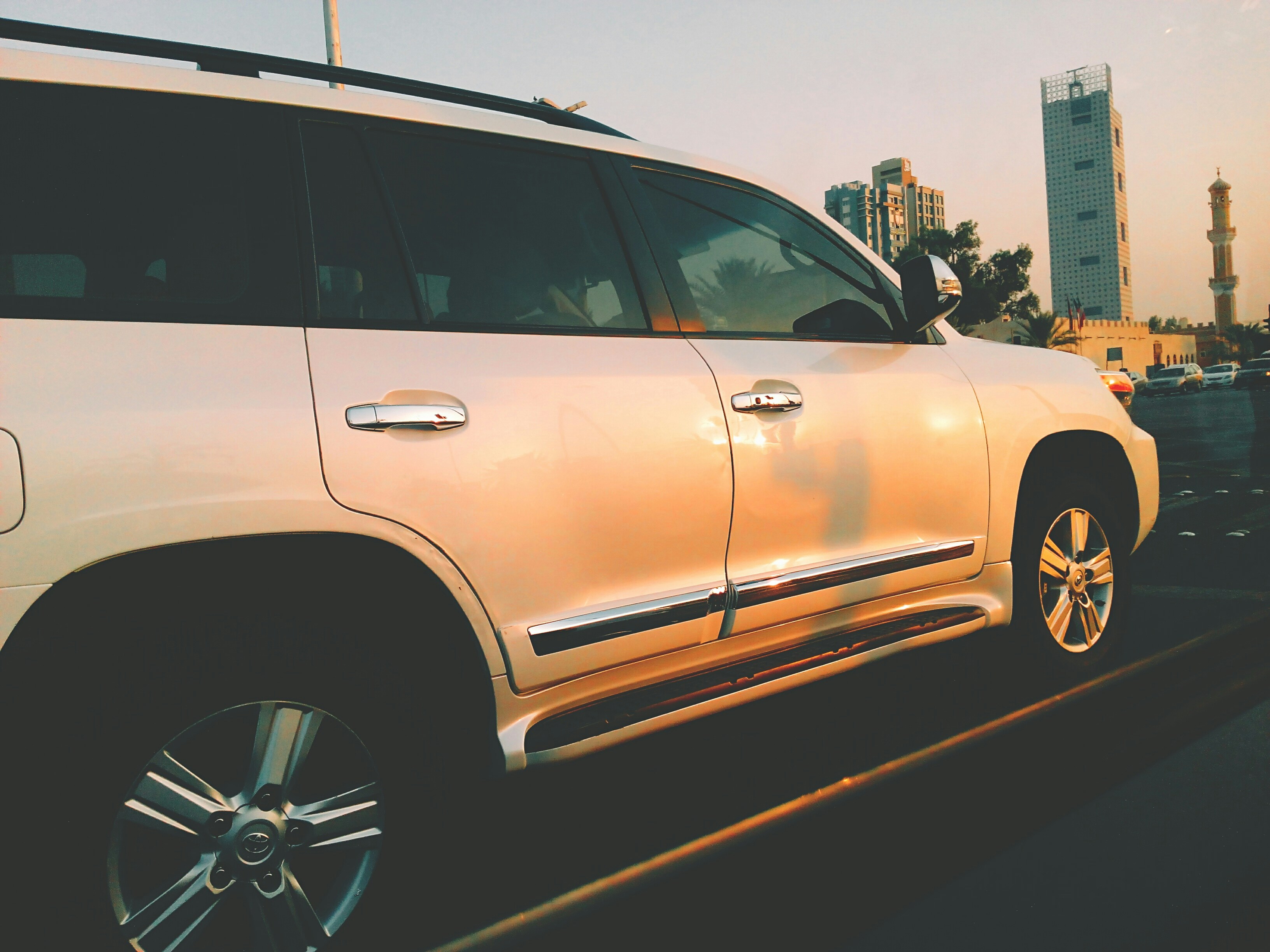 Luxury SUV vehicle parked outside Moroccan riad hotel golden hour warm light