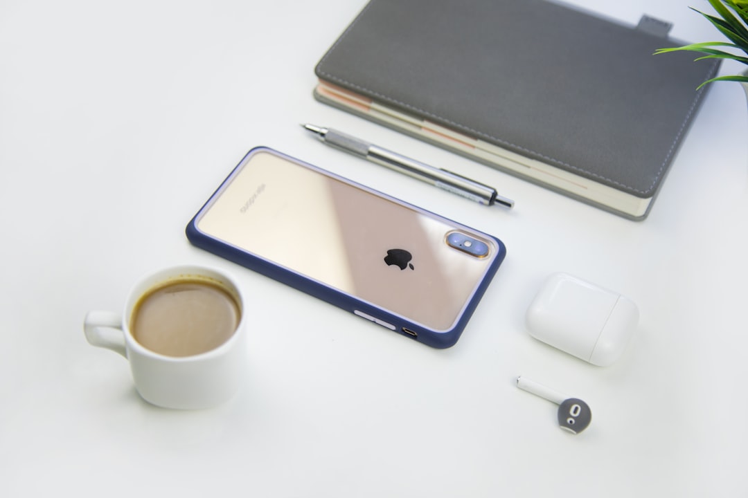 white ceramic mug beside gold iPhone