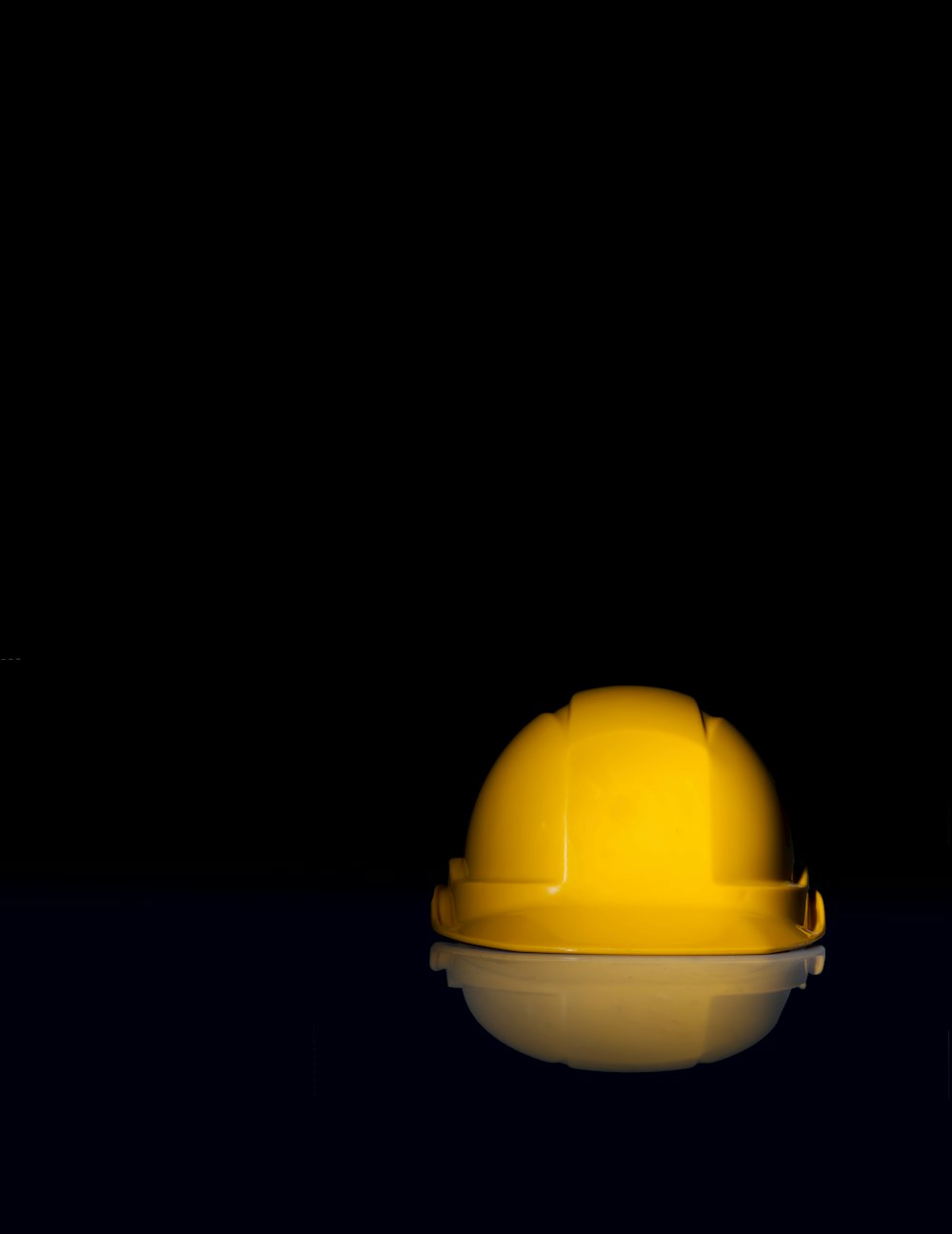 Cappello di sicurezza giallo su superficie nera