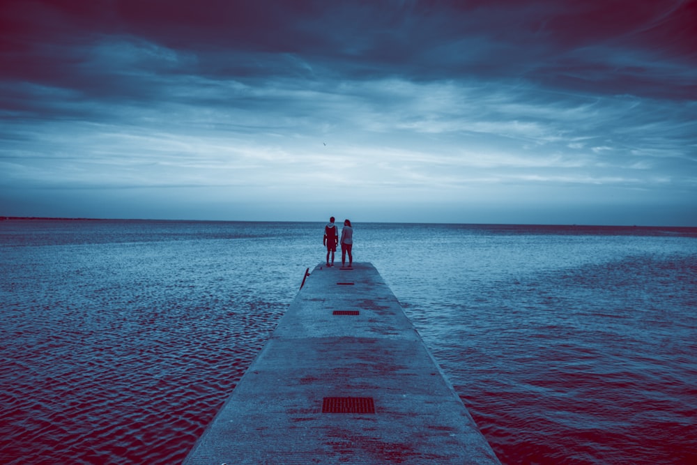 two person facing sea