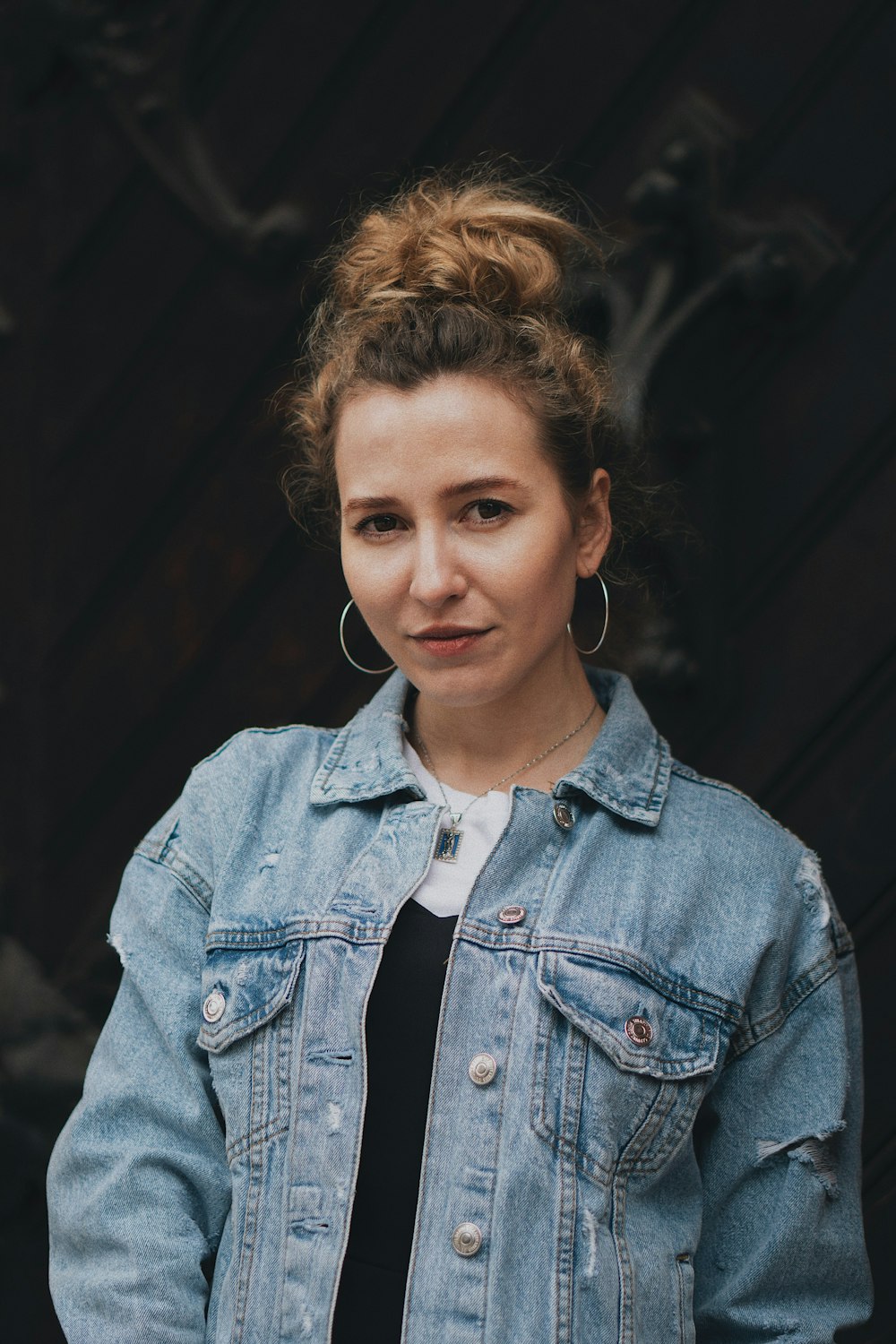 standing woman wearing blue denim jacket