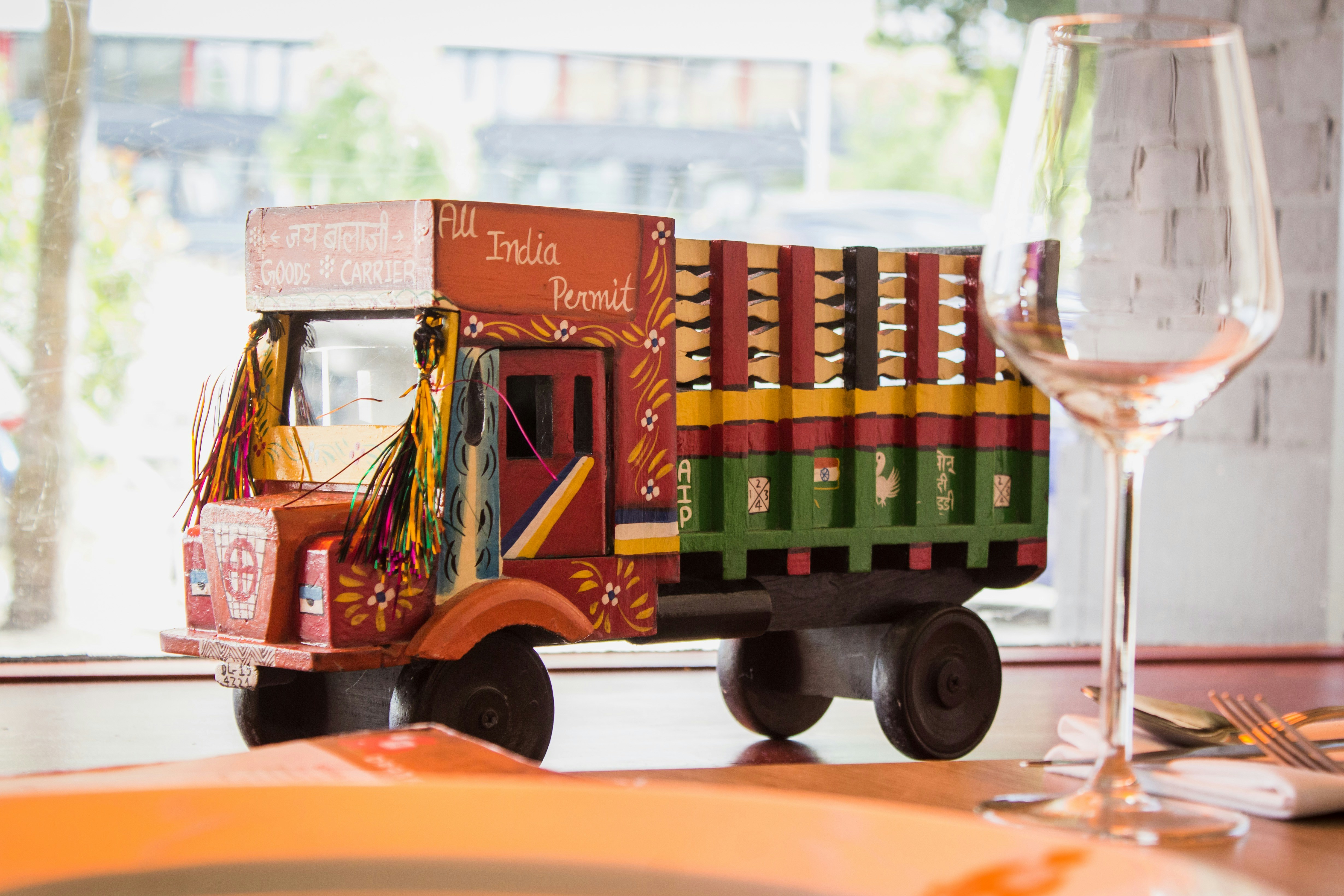Multicolored truck toy near wine glass