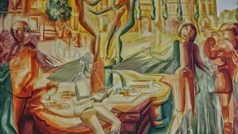 A vibrant mural featuring various figures engaged in different activities within an urban setting. Some people are conversing, others are walking, and one person is reading by a water feature. Trees and buildings provide a backdrop, and the scene evokes a bustling social atmosphere.