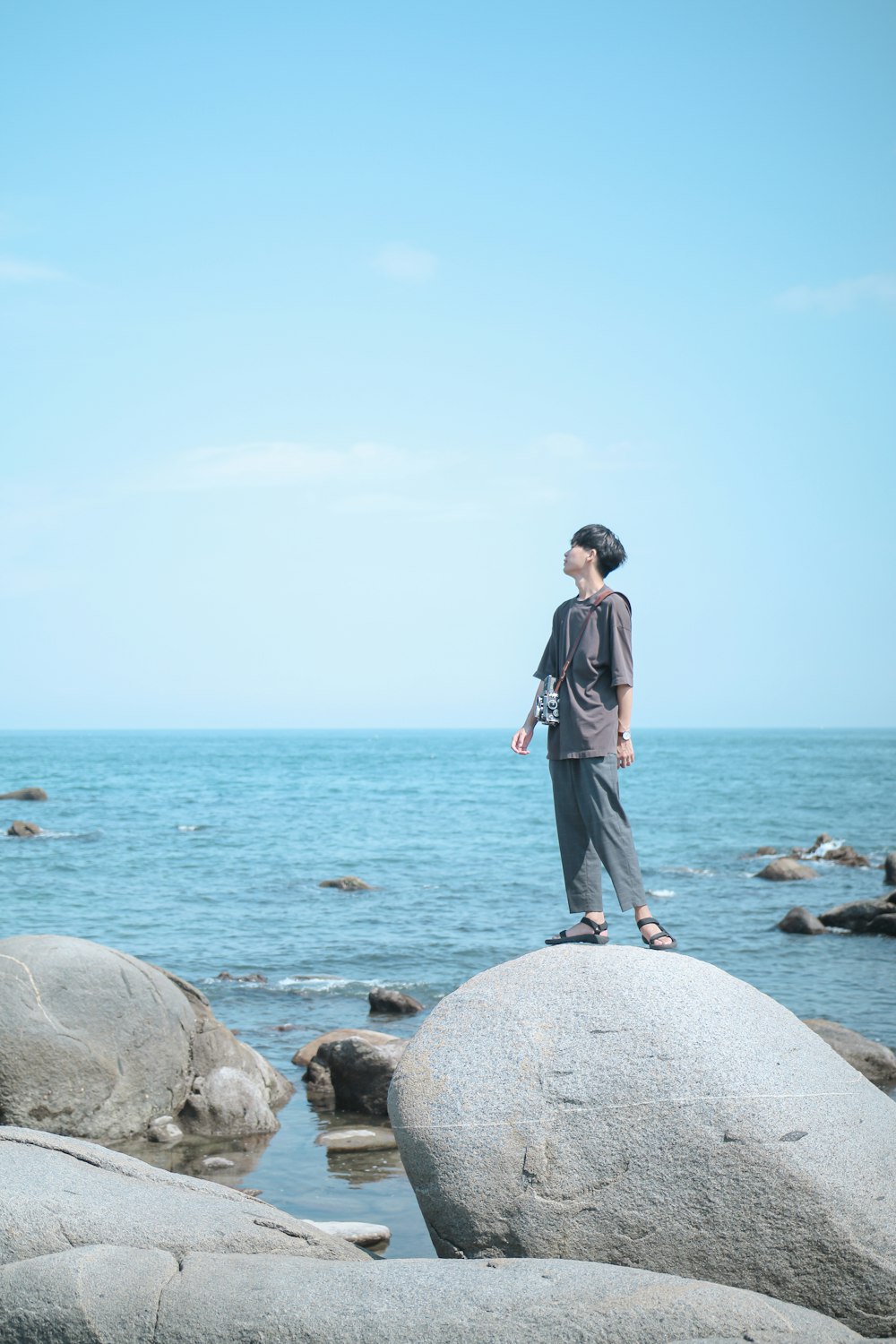 hombre de pie sobre la roca en la orilla del mar