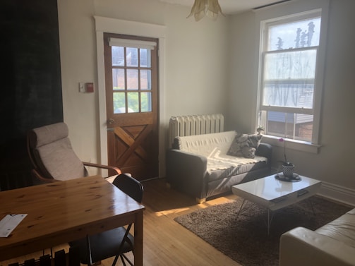 Cozy living room scene featuring a vintage wood sofa and light coffee table bathed in warm sunlight.