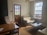 A cozy living room featuring a modern sofa and wooden paneling with natural light.