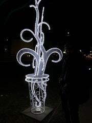 A glowing sculpture mid-transformation, blending metal and light.