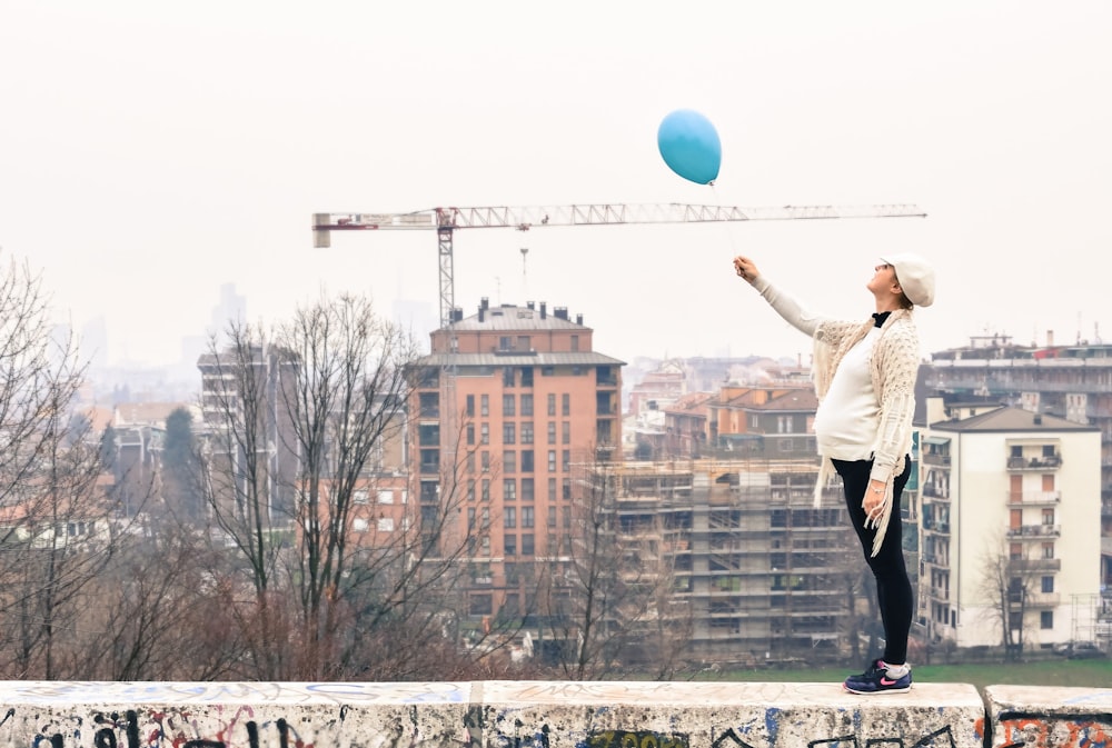 woman on roof holding balloon