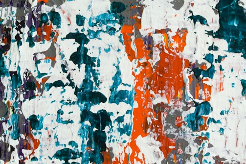 Abstract painting showcasing a blend of bright and vibrant colors with a predominantly chaotic texture. The colors include splashes of teal, orange, white, and intermittent darker and lighter shades spread across the canvas. Thick, overlapping brushstrokes create a textural depth and an intricate pattern.
