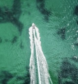 A scenic speedboat cruising over sparkling ocean waves.