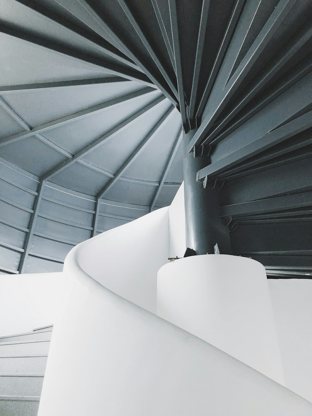 a spiral staircase in a building with white walls