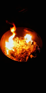 Close-up of pyrolysis equipment converting plastic waste into oil with glowing orange flames inside.