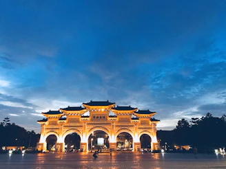 Elegant photograph of Iga Erekọ’s ornate gates framed by deep royal blue skies at dusk.