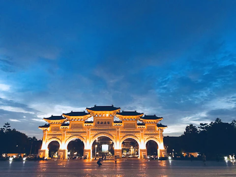 Elegant photograph of Iga Erekọ’s ornate gates framed by deep royal blue skies at dusk.