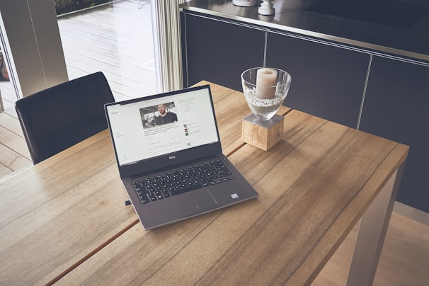 A serene workspace with candles, crystals, and a laptop open to a spiritual learning platform.