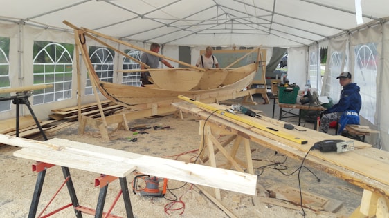 A skilled craftsman carefully shaping a yacht hull inside the Blue n Blue shipyard workshop.