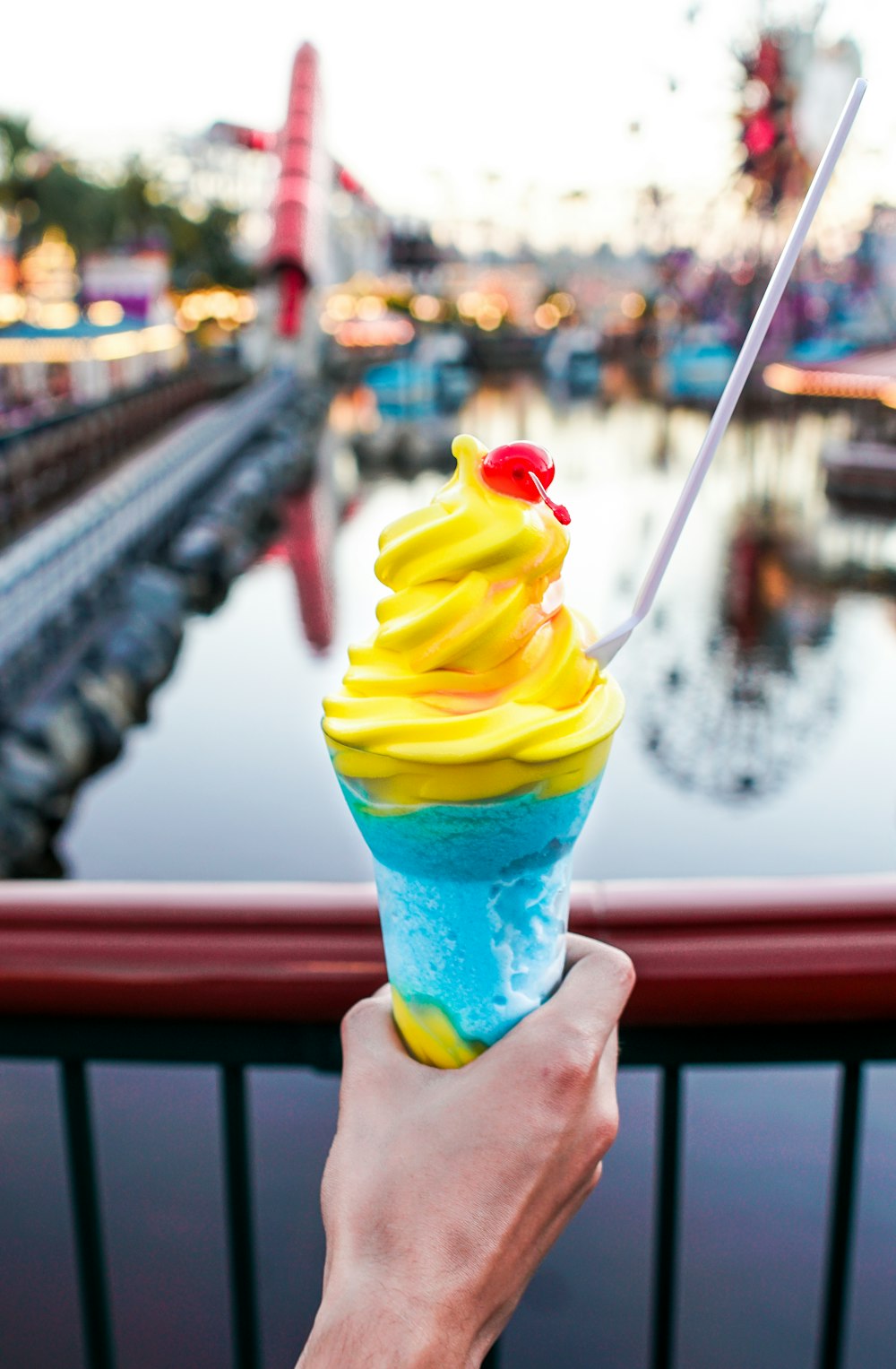 person holding a blue cone yellow ice-cream close-up photography