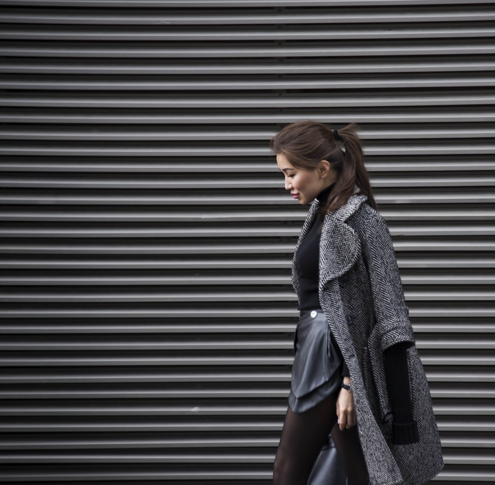 Una mujer caminando por la calle con un abrigo