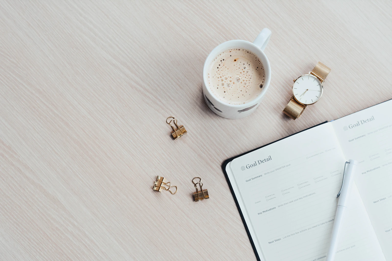 Un bureau clair et rangé, un café et un carnet