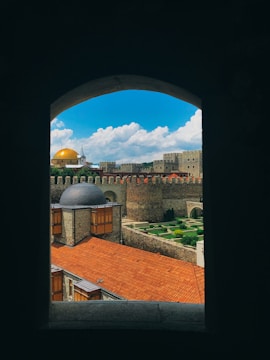 A vibrant photo of the historic Aljafería Palace in Zaragoza under a bright blue sky.