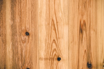 Wooden surface featuring vertical planks with prominent grain patterns and a few knots.
