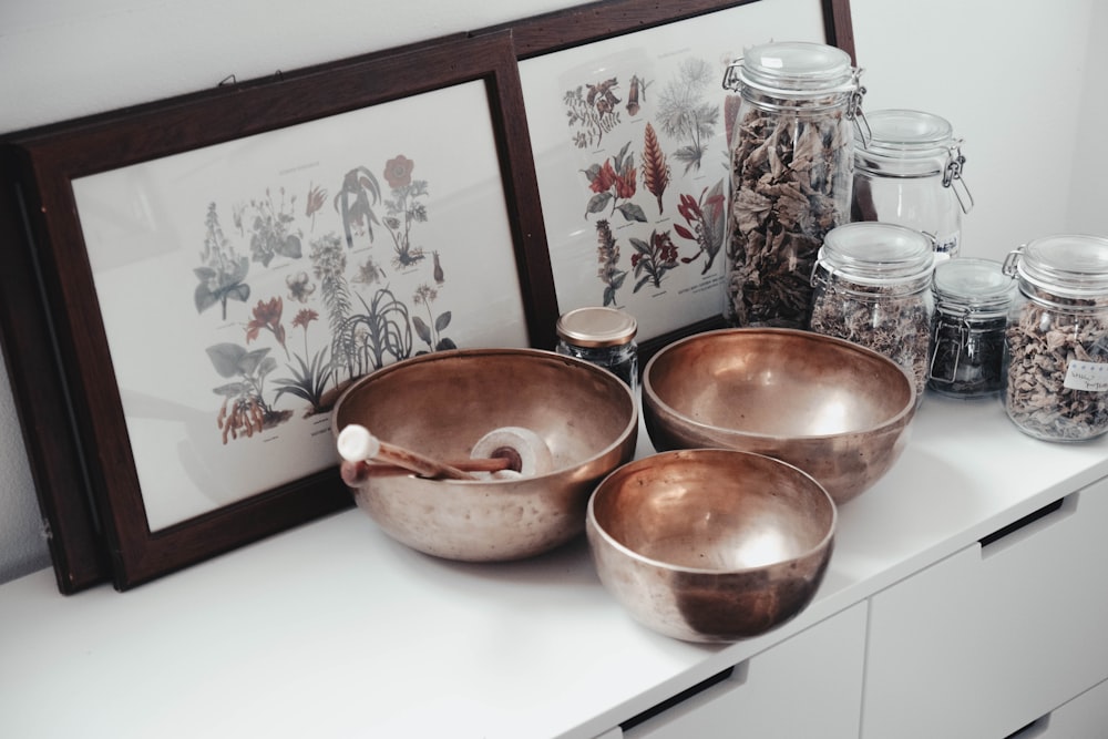 stainless steel bowls on table near framed photos