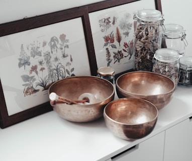 stainless steel bowls on table near framed photos