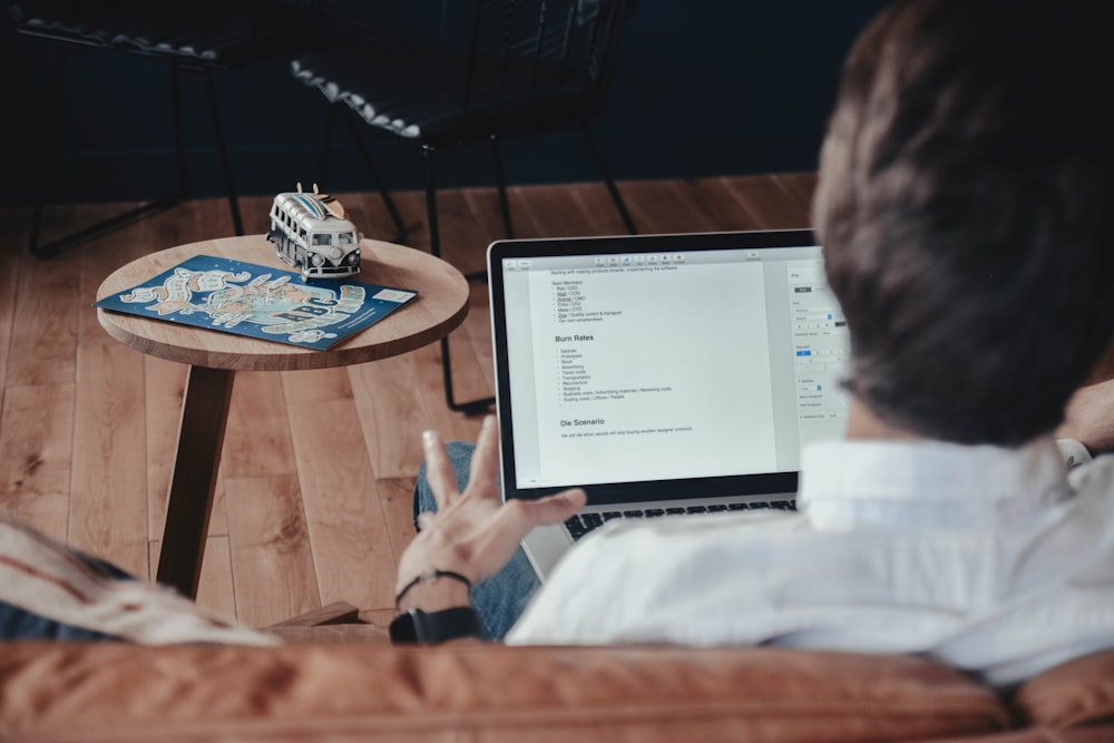 a person sitting on a couch using a laptop