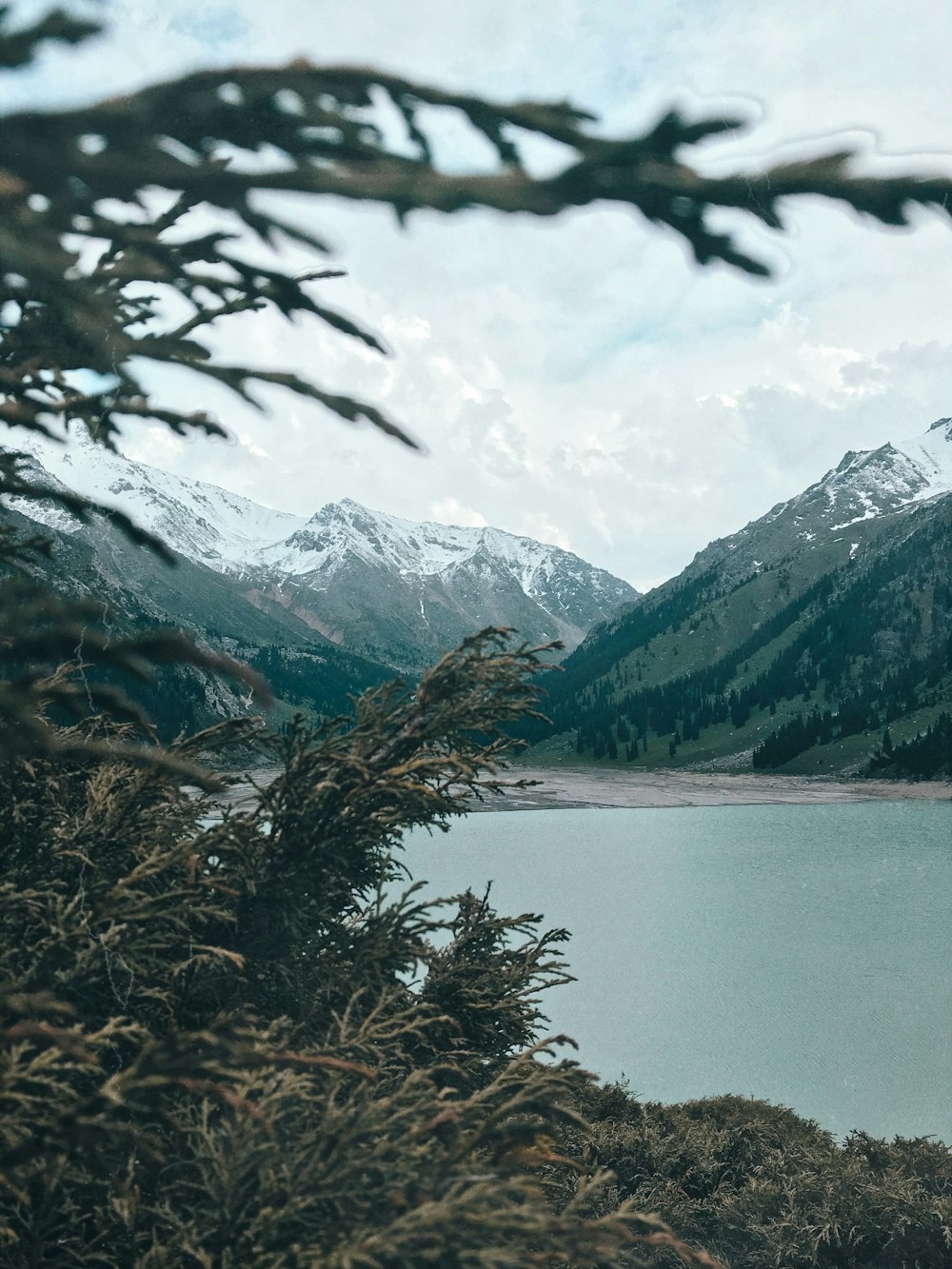 body of water near mountain during daytime