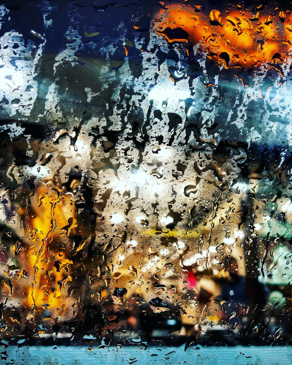 a view of a street through a rain covered window