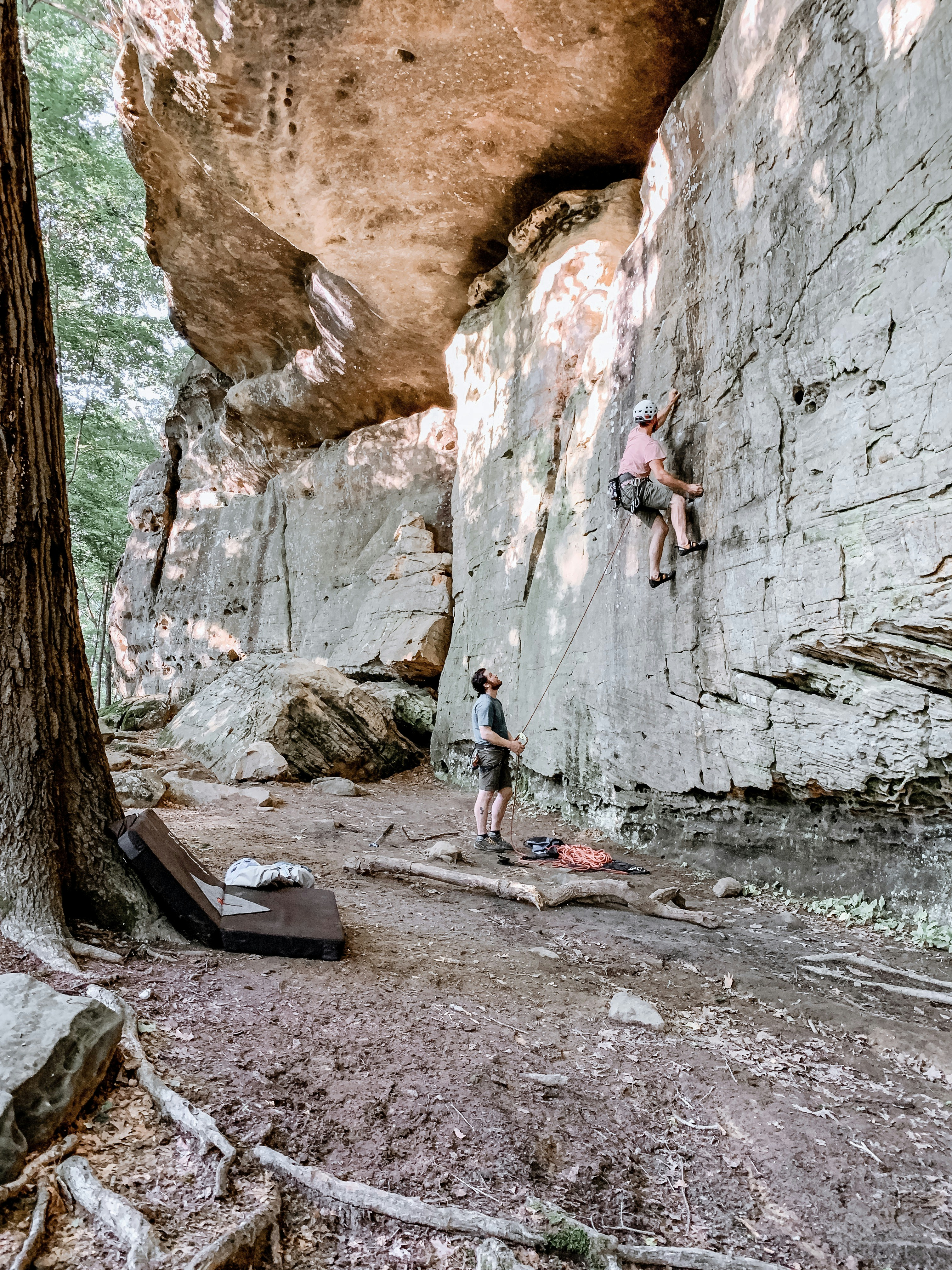 man looking at man climbing on wall