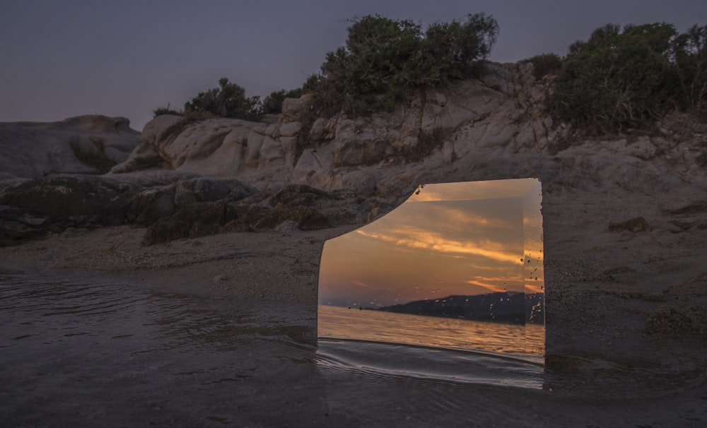 glass mirror on shore during golden hour