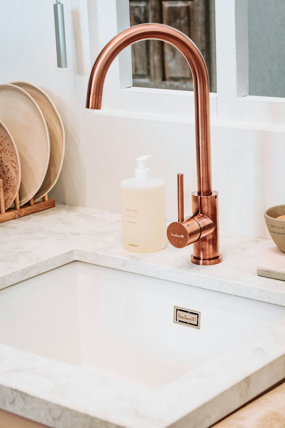 square white sink with brass faucet